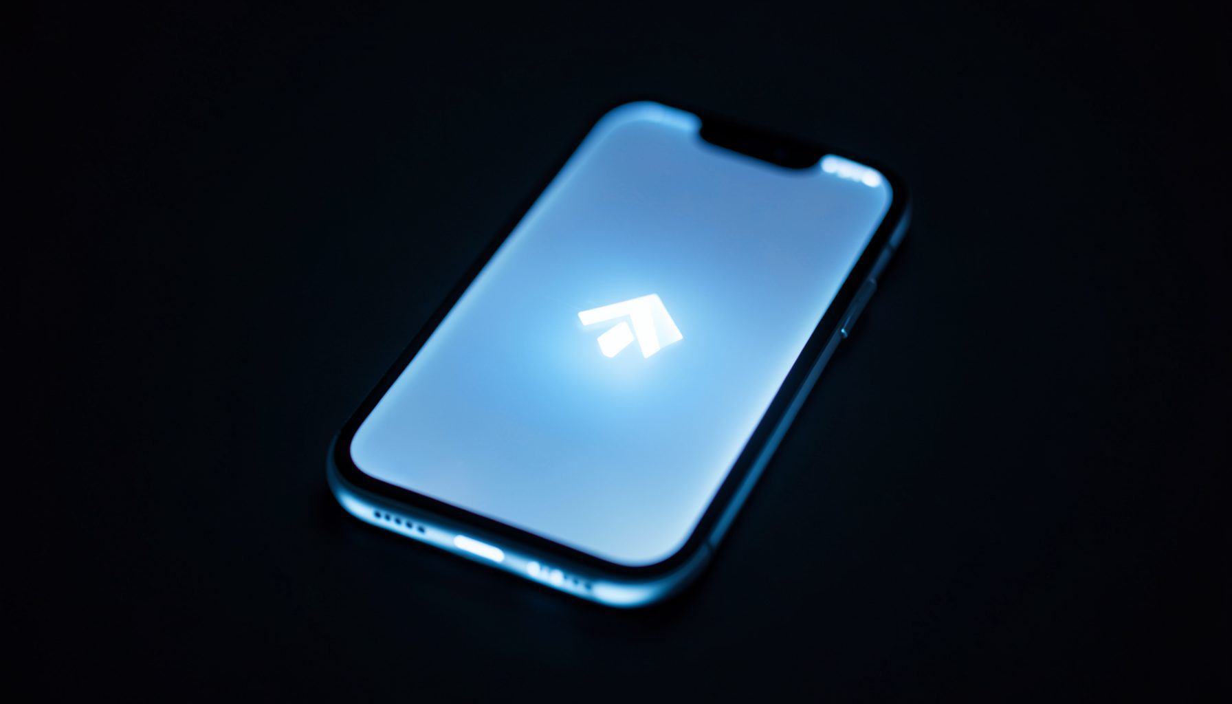 Smartphone glowing with soft blue and white light against a dark background, suggesting a download in progress, calm and modern mood