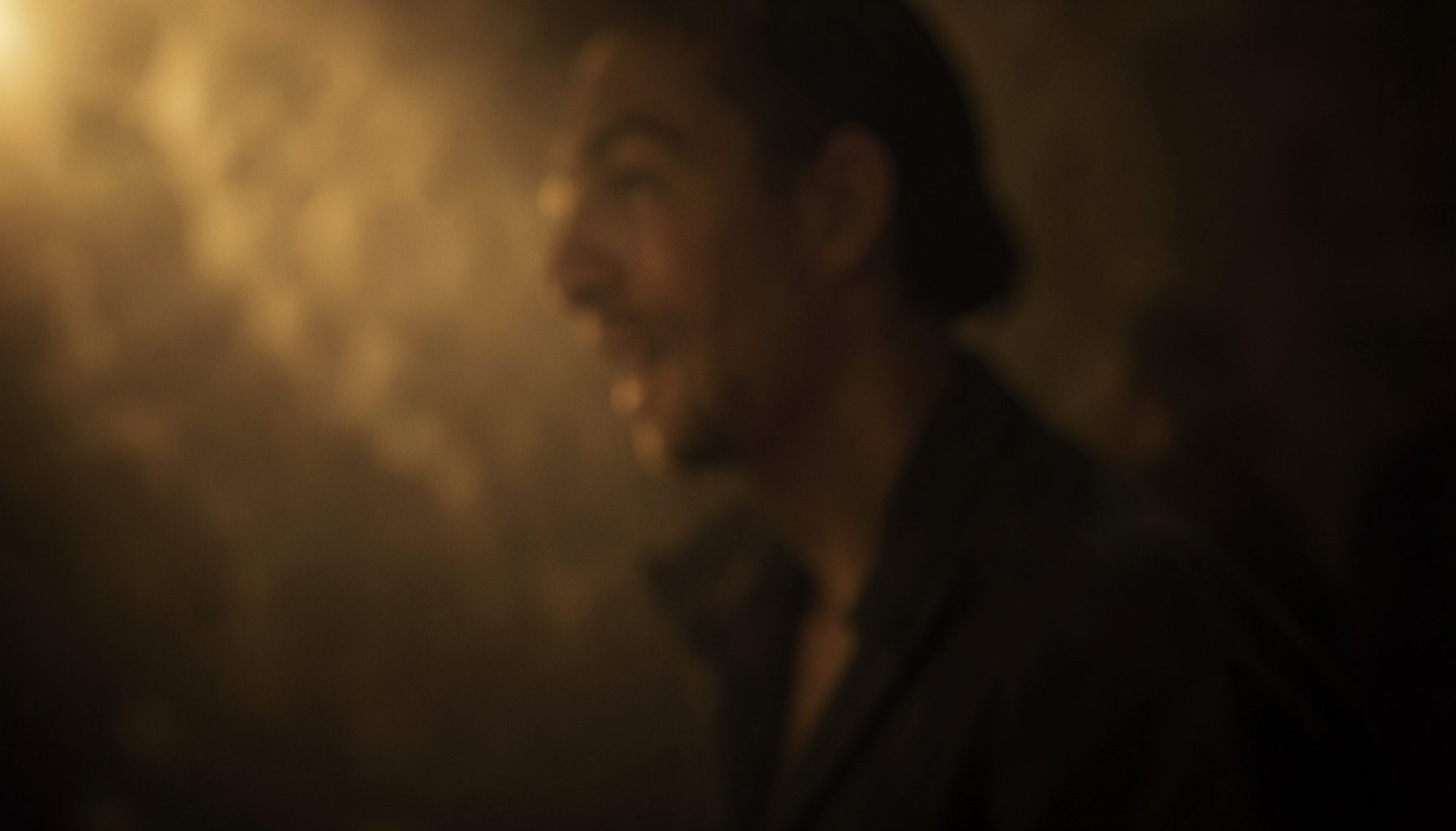 Warm cinematic frame with soft golden light and deep shadows, hinting at an emotional drama film scene